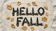 © MST.ANTOR MONI AKTER - Hello fall text written on sand with scattered autumn leaves