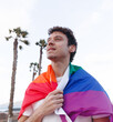 © G.S.Rob - A young man proudly walks along the seashore carrying the LGBTQ flag