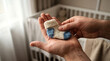 © solom - Father holding a tiny knitted baby sock gently in his hands while standing near the crib in a cozy nursery expecting a newborn child