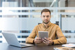 © Liubomir - Digital transformation and remote work, professional man using tablet and laptop for business communication in modern office. Corporate employee managing digital workflow and connectivity.