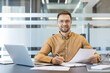 © Liubomir - Professional businessman working in office, corporate success and career development with laptop and documents. Confident male employee reviewing paperwork and planning business strategy at desk.