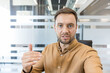 © Liubomir - Professional man talking during a video conference in a modern office, remote work and virtual meeting concept. Businessman explaining strategy and gesturing during a digital call.