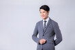 © ChauBich - Smiling young Asian businessman in stylish grey suit against studio background