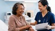 © iravgustin - Senior patient visiting the general practitioner. The older woman laughs heartily sharing a joyful moment with her doctor holding a tablet.