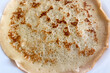 © ir1ska - A round thin crepe cooked with brown spots rests on a plain white background