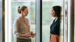© Lita Clarus - Two Businesswomen Having a Conversation in a Modern Office