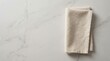 © Spot Decor - Minimalist top down view of a beige linen napkin resting on gray marble.
