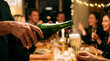 © Marlon - Close up of hand pouring bubbly champagne into a flute glass during a festive dinner party with friends celebrating