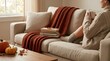 © Xenia - Cozy fall throw blanket on sofa. Autumn decor theme with books and hot drink