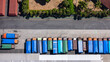 © Amazing Aerial - Aerial view of a line of parked trucks with colorful tarpaulin covers in a logistics yard in Salatiga, Central Java, Indonesia.