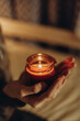 © ADDICTIVE STOCK - Girl hold scented candle in warm cozy home interior