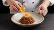 © Rachakrit - Chef hand garnish orange sauce dish plating crispy spiced meat with orange garnish