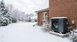 © Elenba - Air source heat pump installed outside a brick house in winter. Residential heating system surrounded by a snow covered landscape