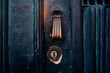 © Loginova - Close up of an antique brass door knocker and keyhole on a weathered dark blue wooden door in Lisbon.