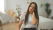 © Krakenimages.com - Woman seated on chair in building holding neck with hand, head tilted and eyes closed in pained expression; discomfort fatigue.