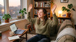 © I - Young woman celebrating success in a home office setting