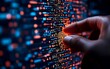 © Halyna - A hand interacts with glowing digital code, highlighting the concept of software development or cybersecurity