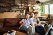 © Marko Geber - Happy mature couple relaxing on sofa in new home living room