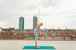 © valbar STUDIO/Stocksy - Yoga Practice on a Rooftop in a City With Tall Buildings