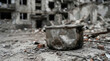 © AI_ID - Damaged cooking pot on rubble in front of destroyed residential building in war zone