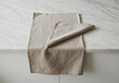 © ziehefzie - Beige linen napkin folded on marble countertop
