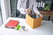 © Charlie's - Businessman Carrying Cardboard Box packing Stuff Resign Depress or carrying business cardboard box Change of job or fired from company resign.