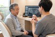 © Harvie Craft - Dentist explaining treatment to an elderly patient with a model with soft natural daylight
