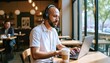 © Athiphat - A freelancer in his 30s at a sunlit coffee shop, typing on a laptop with a latte next to him