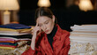 © Tania - A runway model with a debilitating migraine sits in near darkness backstage at twilight, pressing fingertips to her temple beside a stack of folded silk fabric samples, the