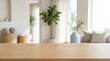 © Nosuya - Empty wooden table top blurred living room interior background with green plants for product mockup display website ads