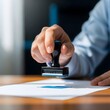 © Saiful Islam B - Document approval a hand applying a stamp to official paperwork