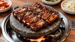 © feng - Korean BBQ galbi short ribs on hot stone plate with banchan side dishes