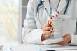 © Pixel-Shot - Female doctor with spine model at table in clinic, closeup