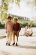 © BGStock72 - Two joyful boys stroll hand in hand along a sunny riverside deck