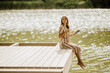© BGStock72 - Woman enjoying a peaceful moment reading by the shimmering lake