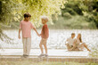© BGStock72 - Two joyful boys sharing a moment by the serene lake in golden sunlight