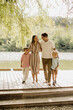 © BGStock72 - Family enjoys a sunny day by the tranquil lake in a serene outdoor setting