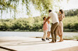 © BGStock72 - Joyful family moments by the serene lake during a sunny afternoon