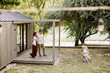 © BGStock72 - Family enjoying a sunny day by their modern cabin near a peaceful river