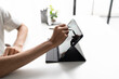 © Charlie's - Using stylus on tablet for digital note taking and productivity technology concept.