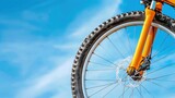 Close-Up of a Mountain Bike Wheel Against a Bright Blue Sky with White Clouds