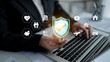 © InfiniteFlow - Business Professional Using Laptop with Digital Shield Icons Representing Security and Protection in Modern Technology Environment. Glyphic.
