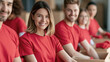 © OHMAl2T - Group of young volunteers wearing red shirts smiling and packing boxes indoors
