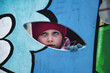 © Aleksandr - Girl Peeking Through a Colorful Playground Cutout During Winter