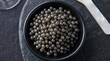 © Ali - Fresh black caviar served in a small black bowl on dark stone