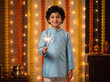 © Someone Cooked Here - cheerful young indian boy in sky blue traditional kurta holding glowing diwali sparkler looking at camera for festive holiday greeting banner