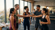 © CLOSE-UP - Diverse group of happy fitness friends fist bumping and celebrating success together in a modern gym