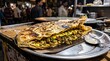 © Nawab - Authentic street food paratha stuffed with meat and eggs, traditional spicy flatbread on a metal plate, delicious local cuisine at a night market