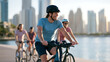 © Liliya - Group of happy friends riding bicycles together in the city, enjoying an active lifestyle outdoors by the waterfront on a sunny day.