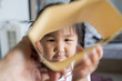© banjongseal324 - Cute Asian Toddler Girl Peering Through Open Brown Cardboard Sleeve Frame,A close-up lifestyle photograph of a playful cute young Asian toddler girl peering through an open brown paper envelope.